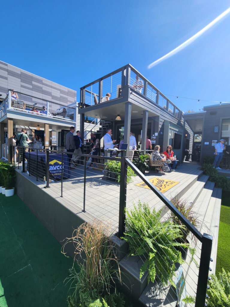 cavco manufactured homes international builder's show 2025 open concept multi-level deck space people sitting in sun eating drinking talking