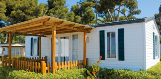 GoliathTech Breaks New Ground in Home Installation manufactured home white black shutters covered patio hedges trees in background advanced home installation helical piles