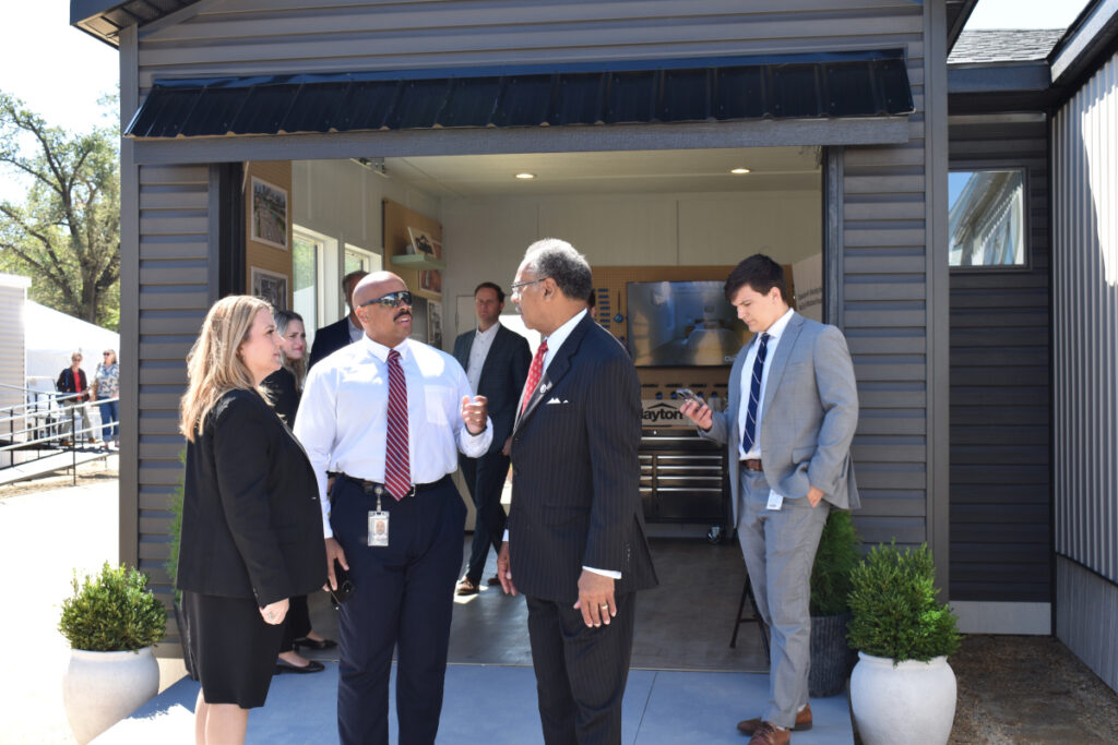 outside meeting manufactured housing professionals hud innovative housing showcase 2025 mhi lesli gooch missouri congressman emanuel cleaver and staff in front of garage