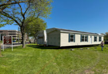 Michigan Hits New Strides in Bringing ‘Homes to the People’ outdoor park public display of manufactured home set up green grass blue sky michigan public park
