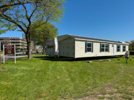 Michigan Hits New Strides in Bringing ‘Homes to the People’ outdoor park public display of manufactured home set up green grass blue sky michigan public park