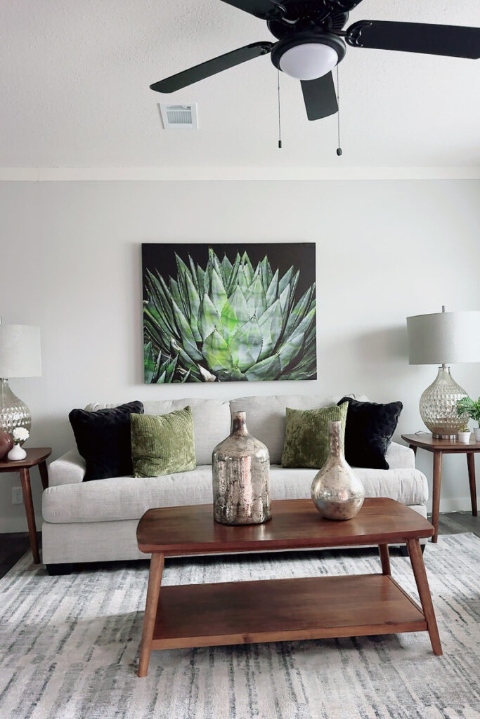 natural elements plants stone glass decor living room lighting soothing tones sofa pillows celing fan